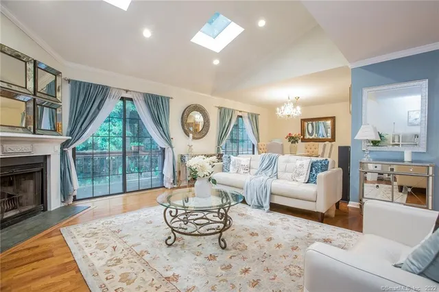 a living room with furniture a fireplace and a floor to ceiling window