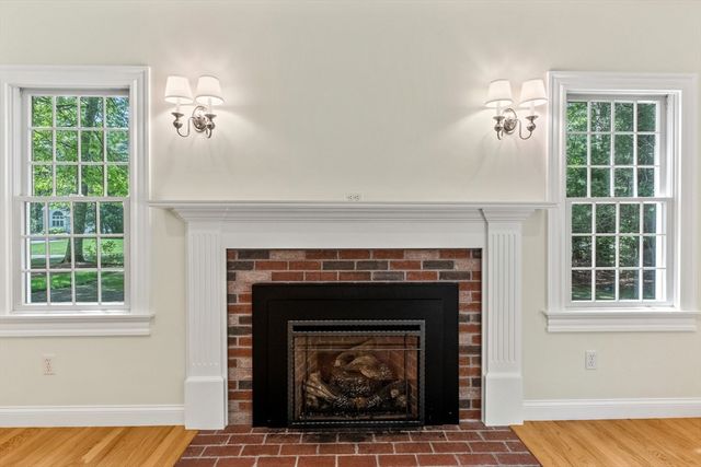 a living room with a fireplace and windows