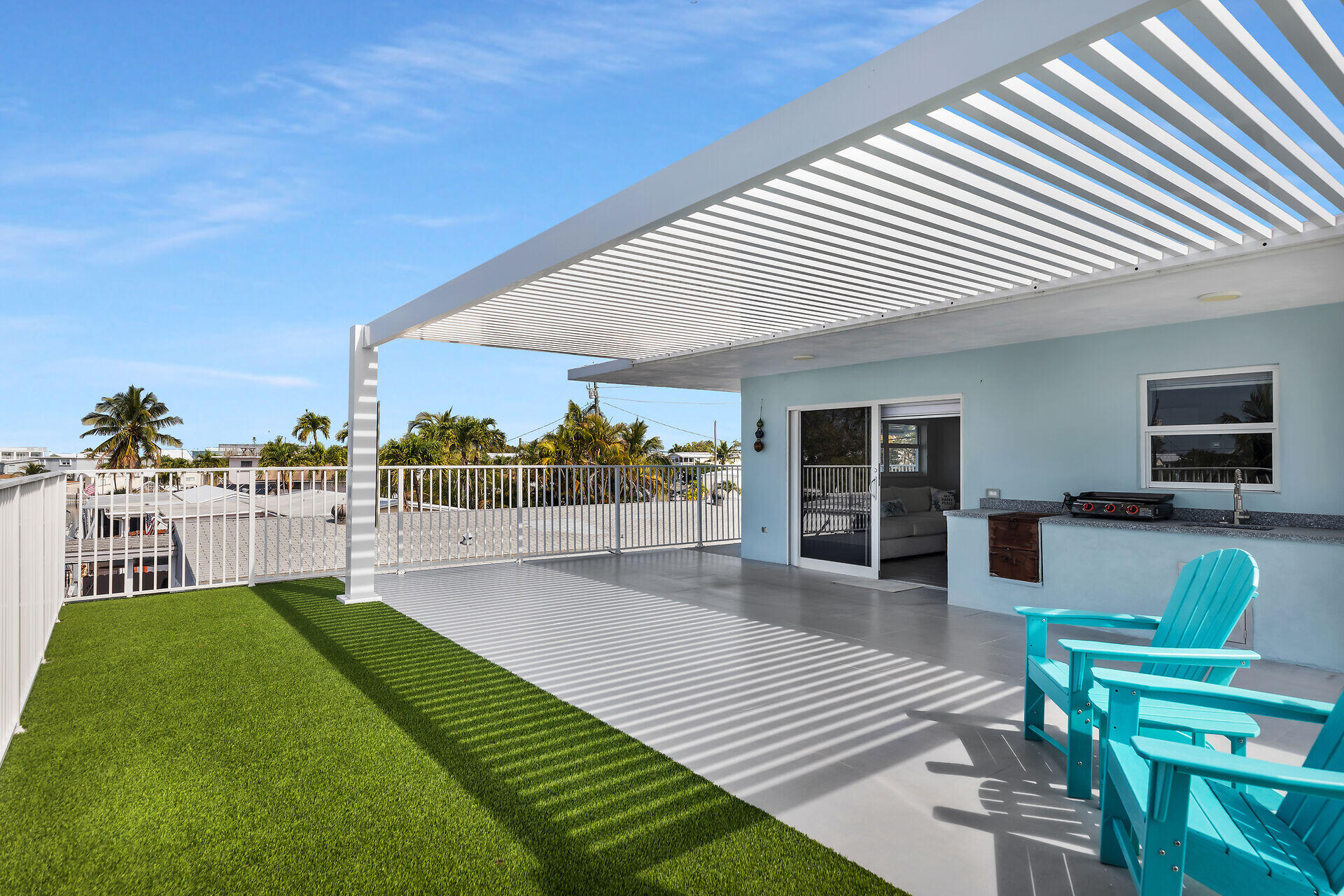 1007 Hialeah Lane Key Largo, FL 33037 - Photo 7 of 41 a view of a patio with dining table and chairs with wooden floor and fence