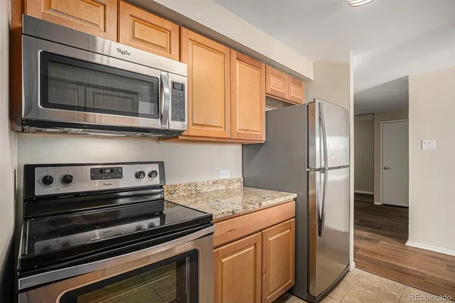 a kitchen with stainless steel appliances granite countertop a stove microwave and refrigerator