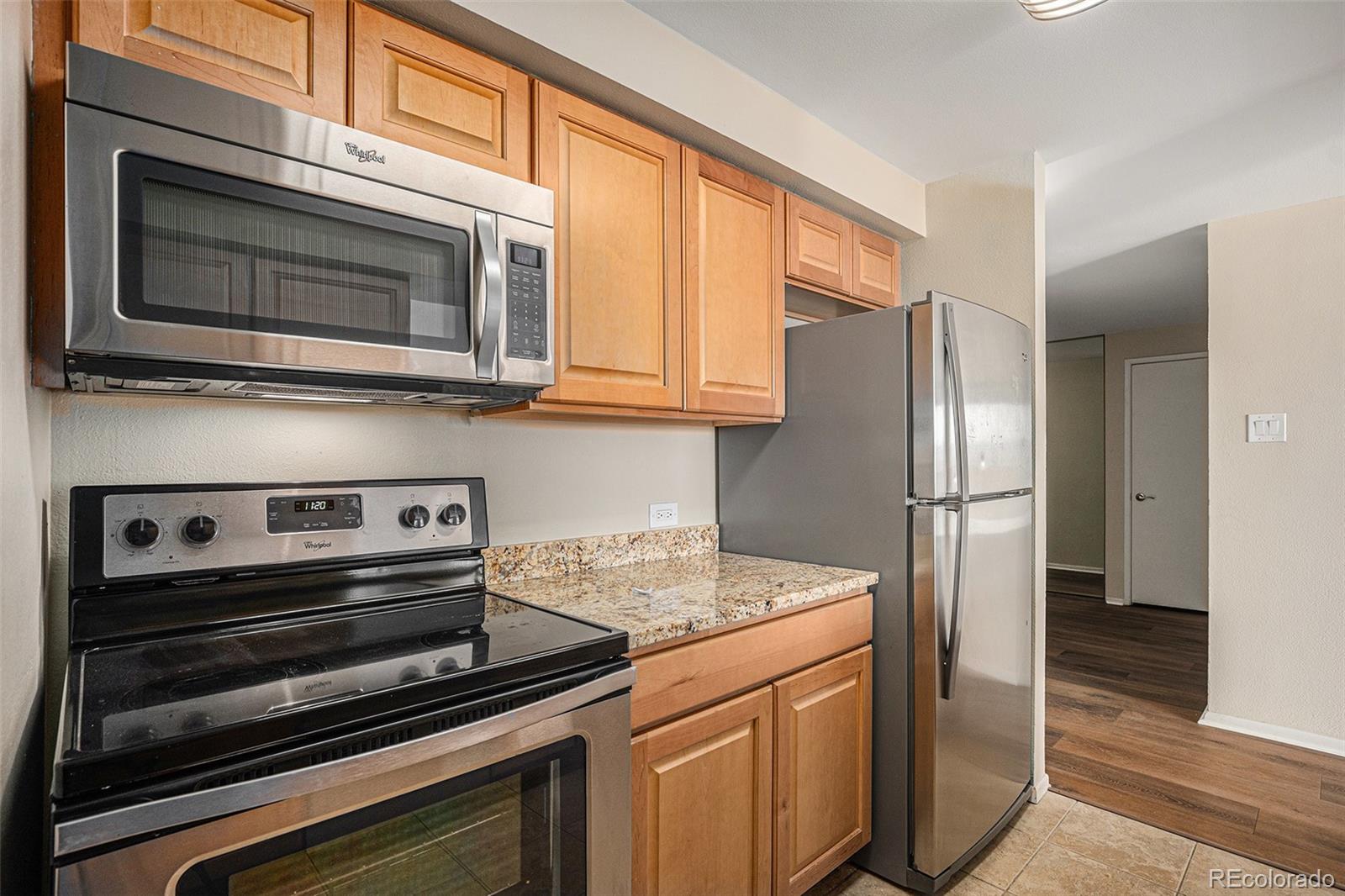1020 15th Street, Unit 20N Denver, CO 80202 - Photo 6 of 10 a kitchen with stainless steel appliances granite countertop a stove microwave and refrigerator