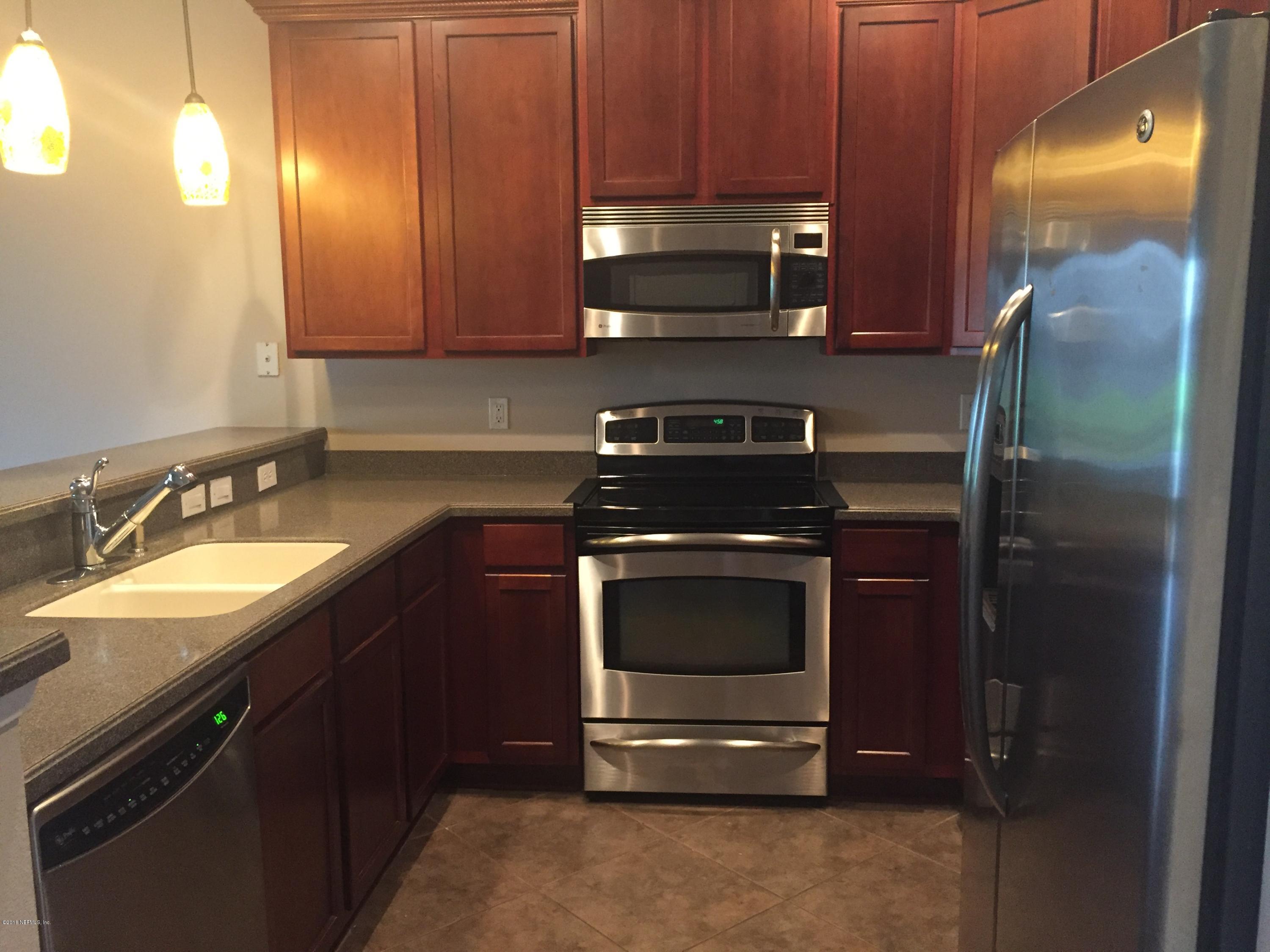 12978 Spring Rain Road Jacksonville, FL 32258 - Photo 6 of 17 a kitchen with stainless steel appliances granite countertop a stove microwave and refrigerator