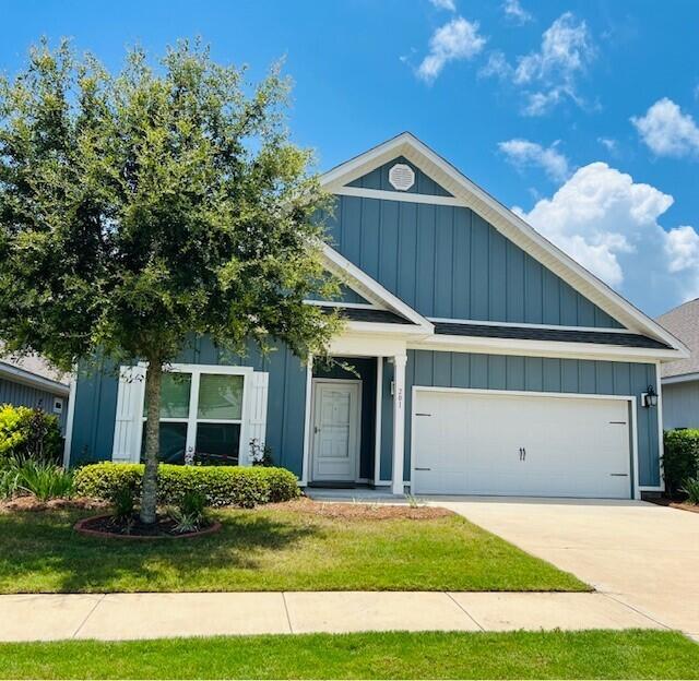 a view of a house with a yard and large trees