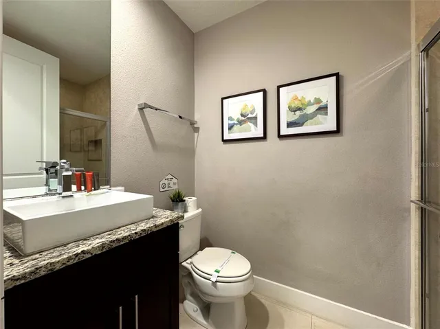 a bathroom with a granite countertop toilet sink and mirror