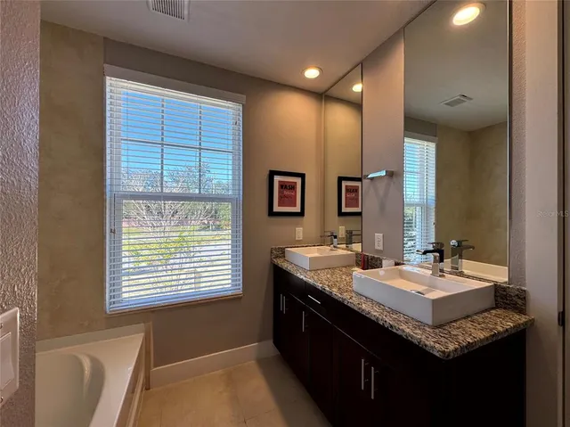 a bathroom with a granite countertop sink and a mirror