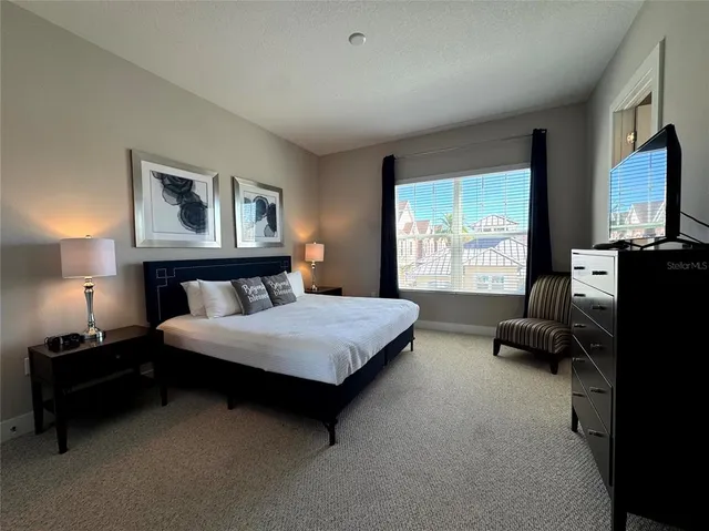 a bedroom with a bed flat screen tv and window