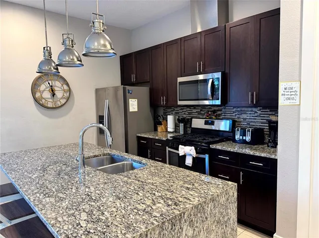 a kitchen with a appliances a sink and cabinets