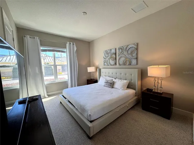 a bedroom with a bed lamp and a window