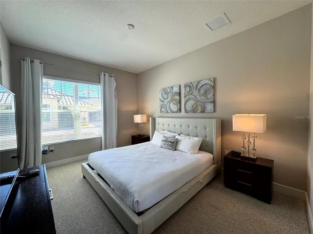 a bedroom with a bed and a lamp on table