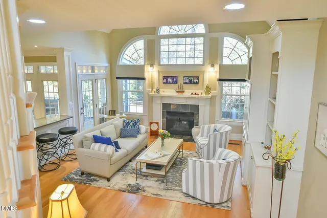 a living room with furniture a fireplace and a chandelier