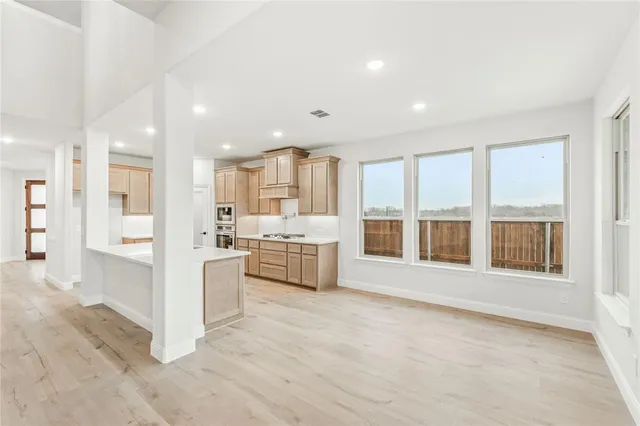 a view of an empty room with a window and fireplace