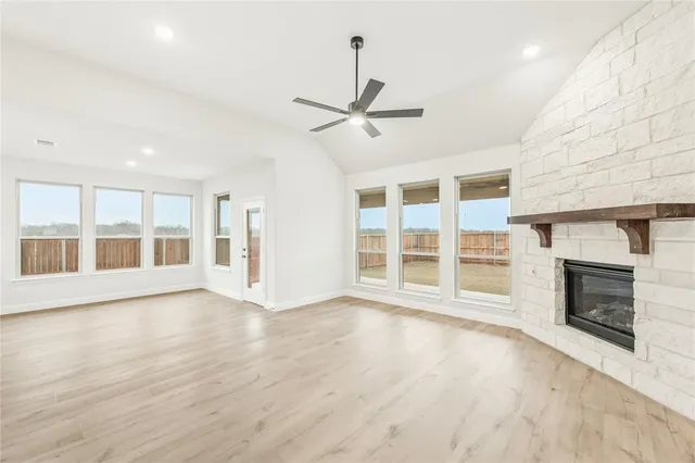 an empty room with ceiling fan and window