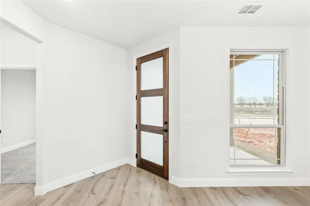 a view of a room with a chandelier fan and wooden floor