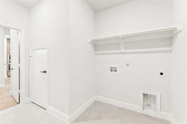 an empty room with wooden floor a fireplace and windows