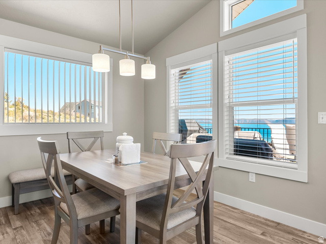 608 Fremont Road Fish Haven, ID 83287 - Photo 14 of 35 Dining area featuring ample natural light, a vaulted ceiling, wood-finish flooring, and multiple windows with horizontal blinds