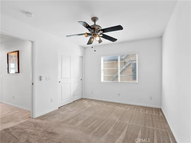 a view of a livingroom with a ceiling fan and window
