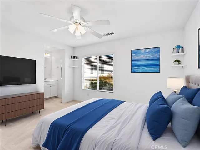 a spacious bedroom with a bed and a flat screen tv