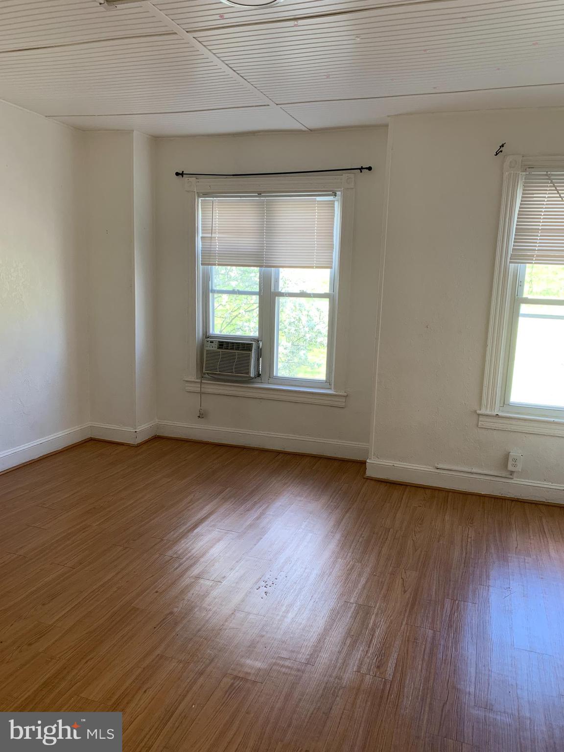 2125 East Preston Street Baltimore, MD 21213 - Photo 6 of 6 an empty room with wooden floor and windows