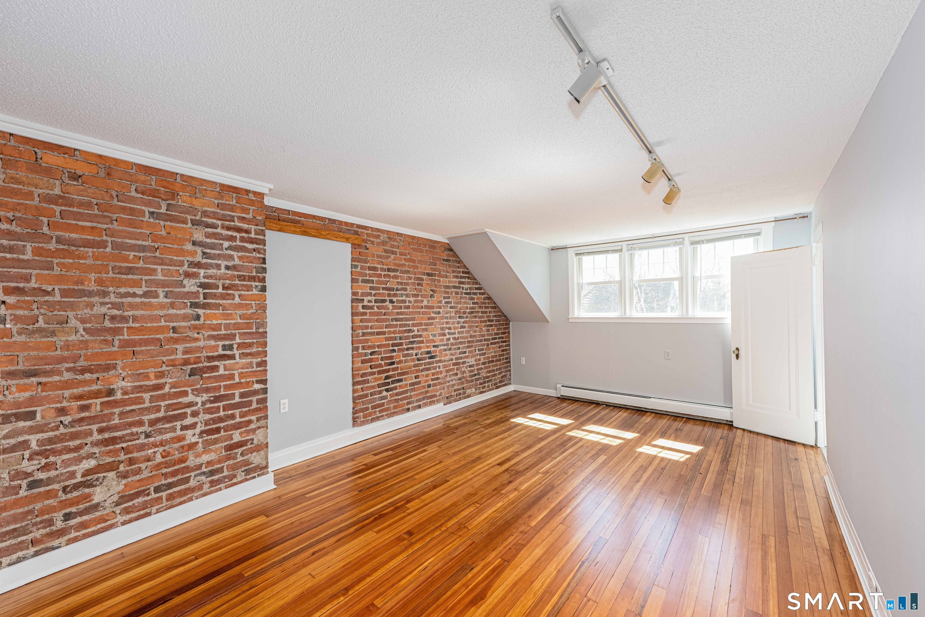 148 Everit Street, Unit F New Haven, CT 06511 - Photo 14 of 26 a view of an empty room with wooden floor and a window