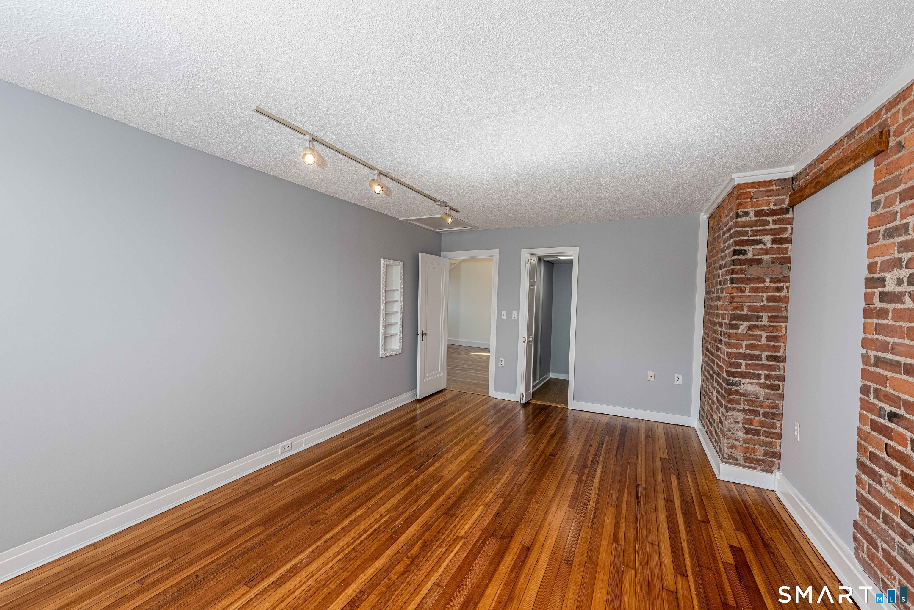 148 Everit Street, Unit F New Haven, CT 06511 - Photo 16 of 26 a view of an empty room with wooden floor and a window