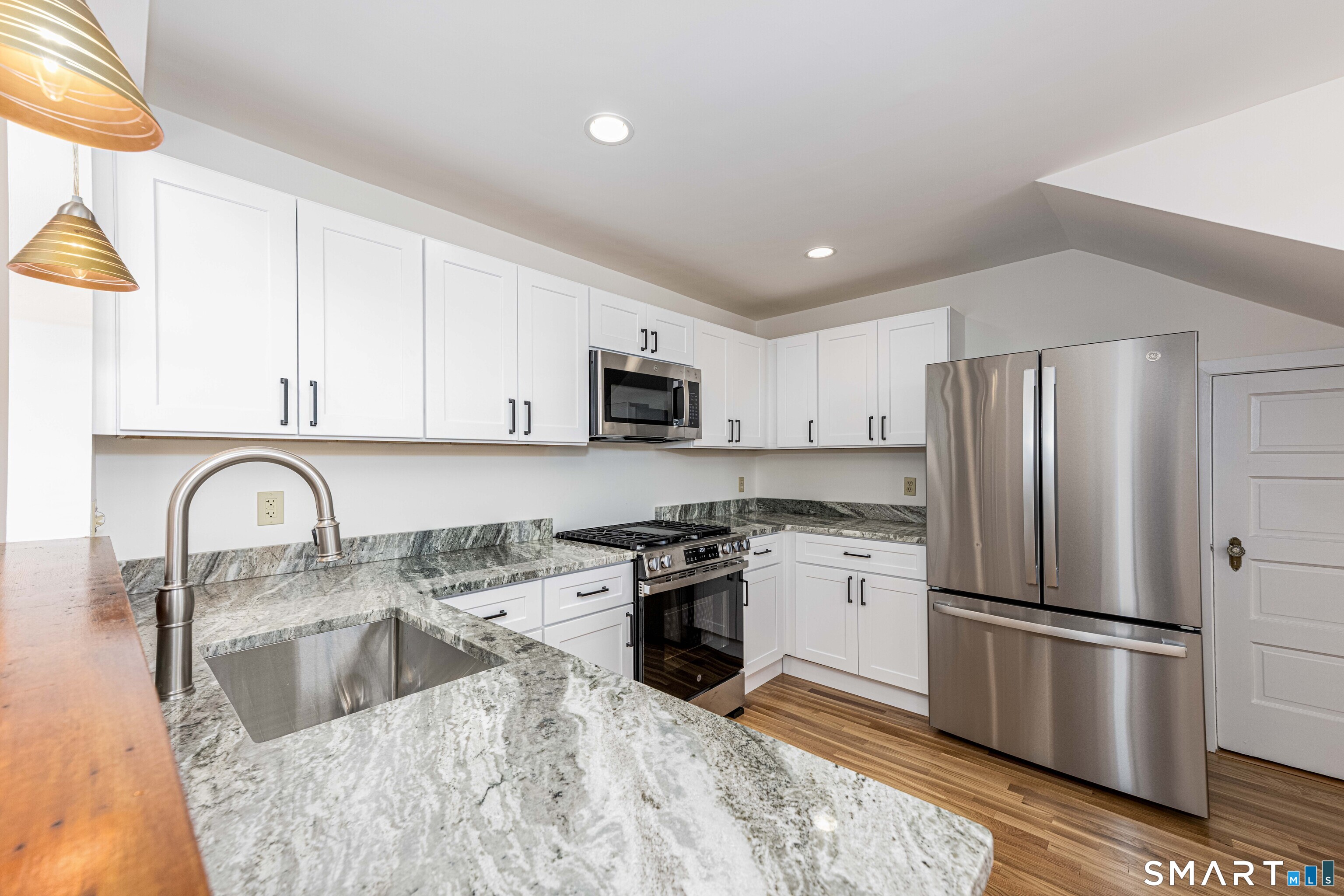 148 Everit Street, Unit F New Haven, CT 06511 - Photo 8 of 26 a kitchen with stainless steel appliances granite countertop a refrigerator a stove a sink a microwave and cabinets