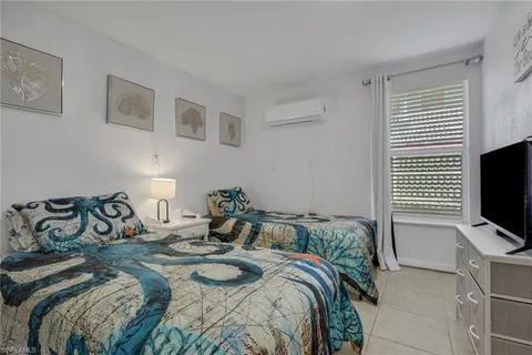 a bedroom with a bed and flat screen tv