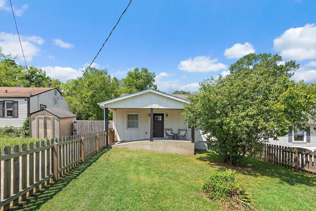 a view of a house with a yard and potted plants