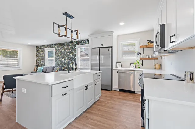 a kitchen with kitchen island white cabinets and refrigerator