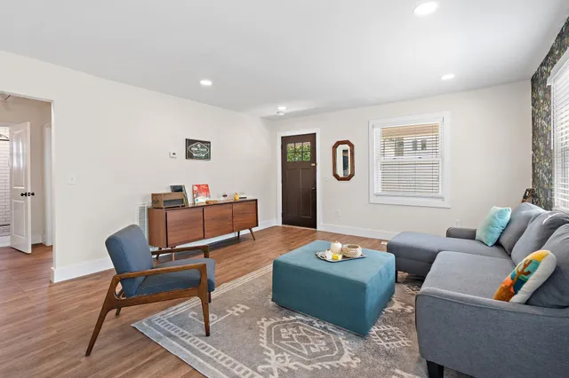 a living room with furniture and a wooden floor