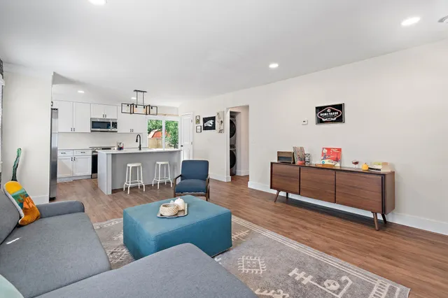 a living room with furniture and a wooden floor