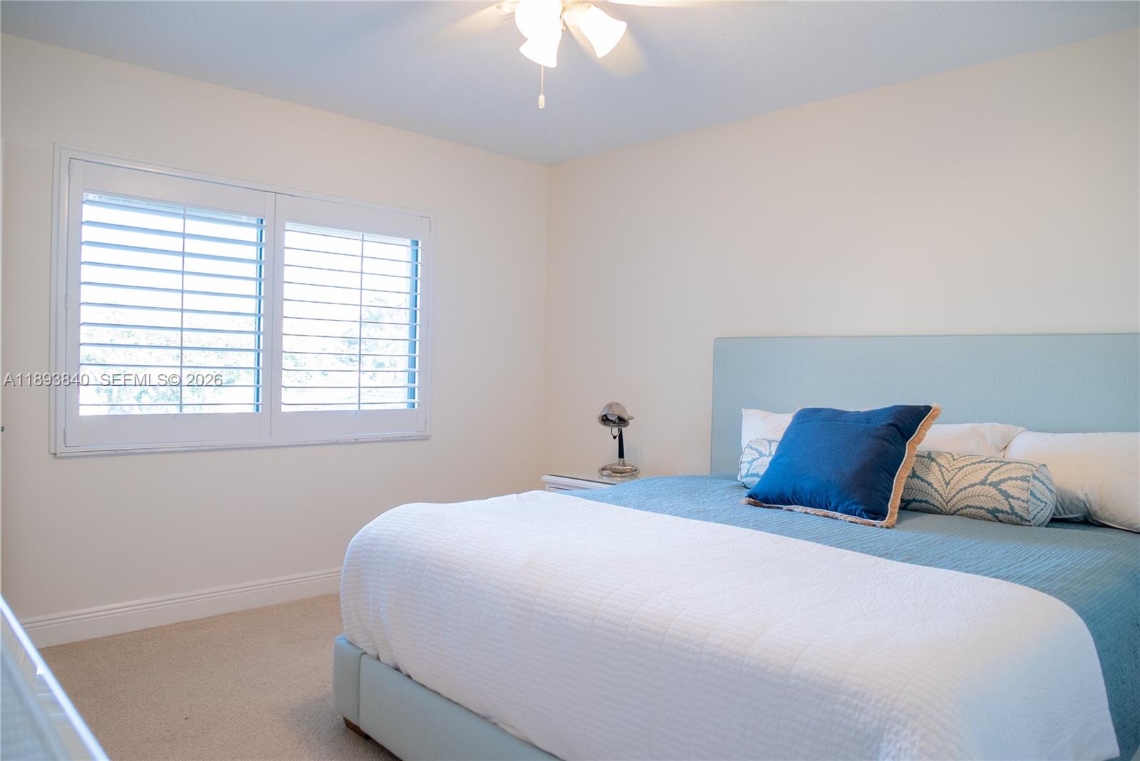 17081 Waterbend Drive, Unit 227 Jupiter, FL 33477 - Photo 27 of 38 a bedroom with a large bed and a chandelier