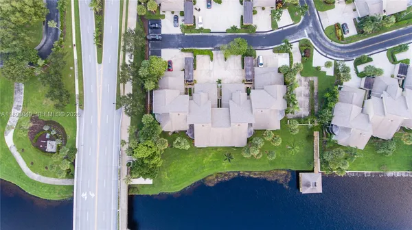 an aerial view of a house with a garden and lake view