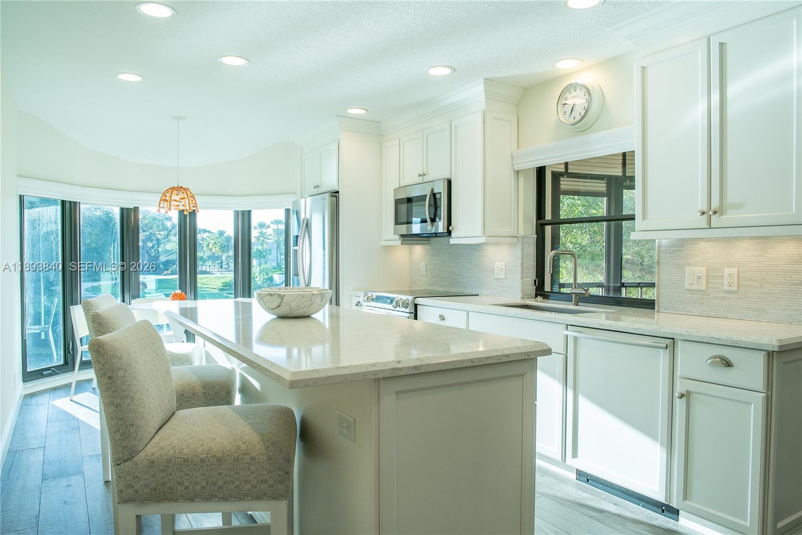 17081 Waterbend Drive, Unit 227 Jupiter, FL 33477 - Photo 6 of 38 a kitchen with a table chairs sink and cabinets