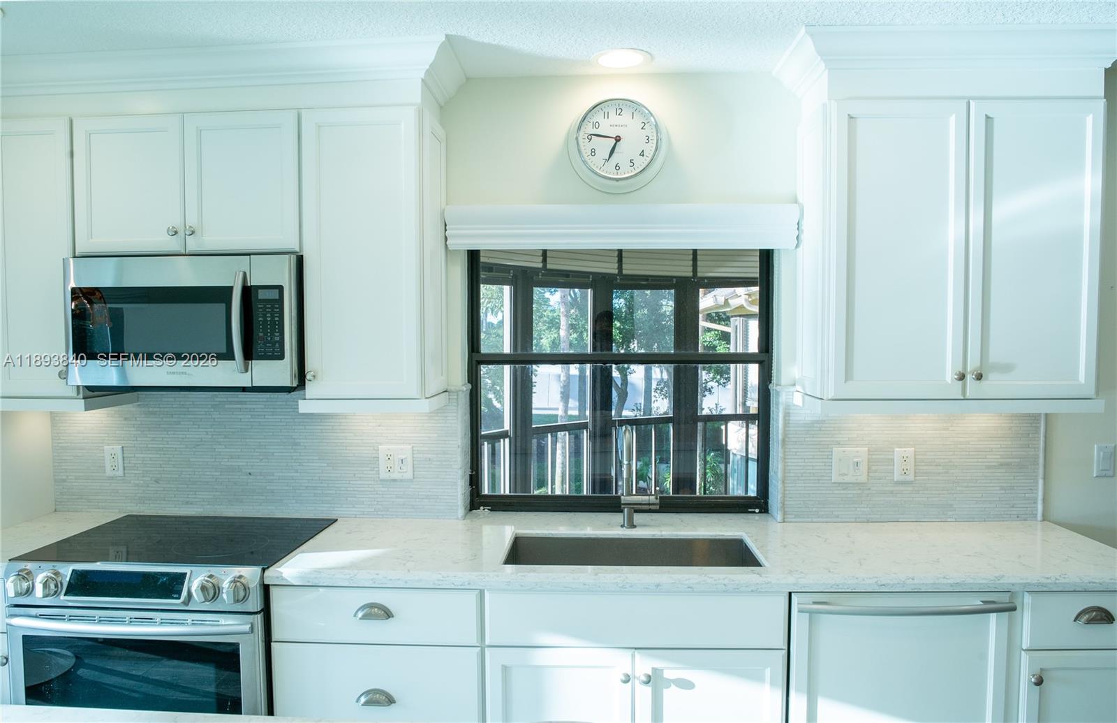 17081 Waterbend Drive, Unit 227 Jupiter, FL 33477 - Photo 8 of 38 a kitchen with a stove and a microwave