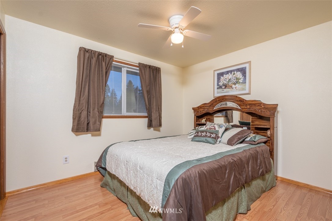 209 Vista Road Chehalis, WA 98532 - Photo 12 of 22 a bedroom with a bed and a chandelier