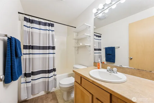 a bathroom with a sink toilet a mirror and shower