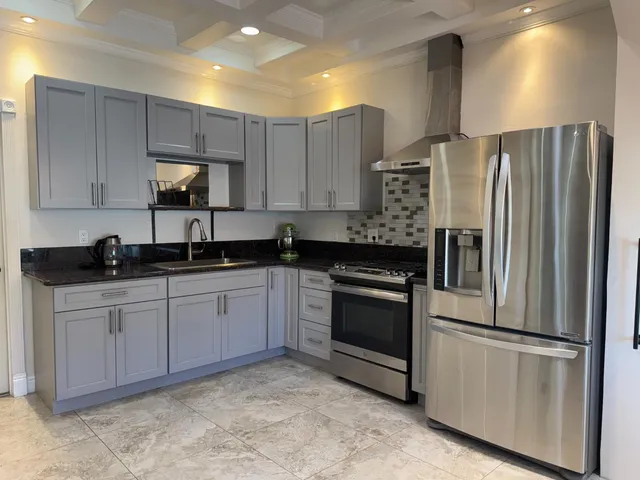 a kitchen with stainless steel appliances granite countertop a refrigerator sink and stove