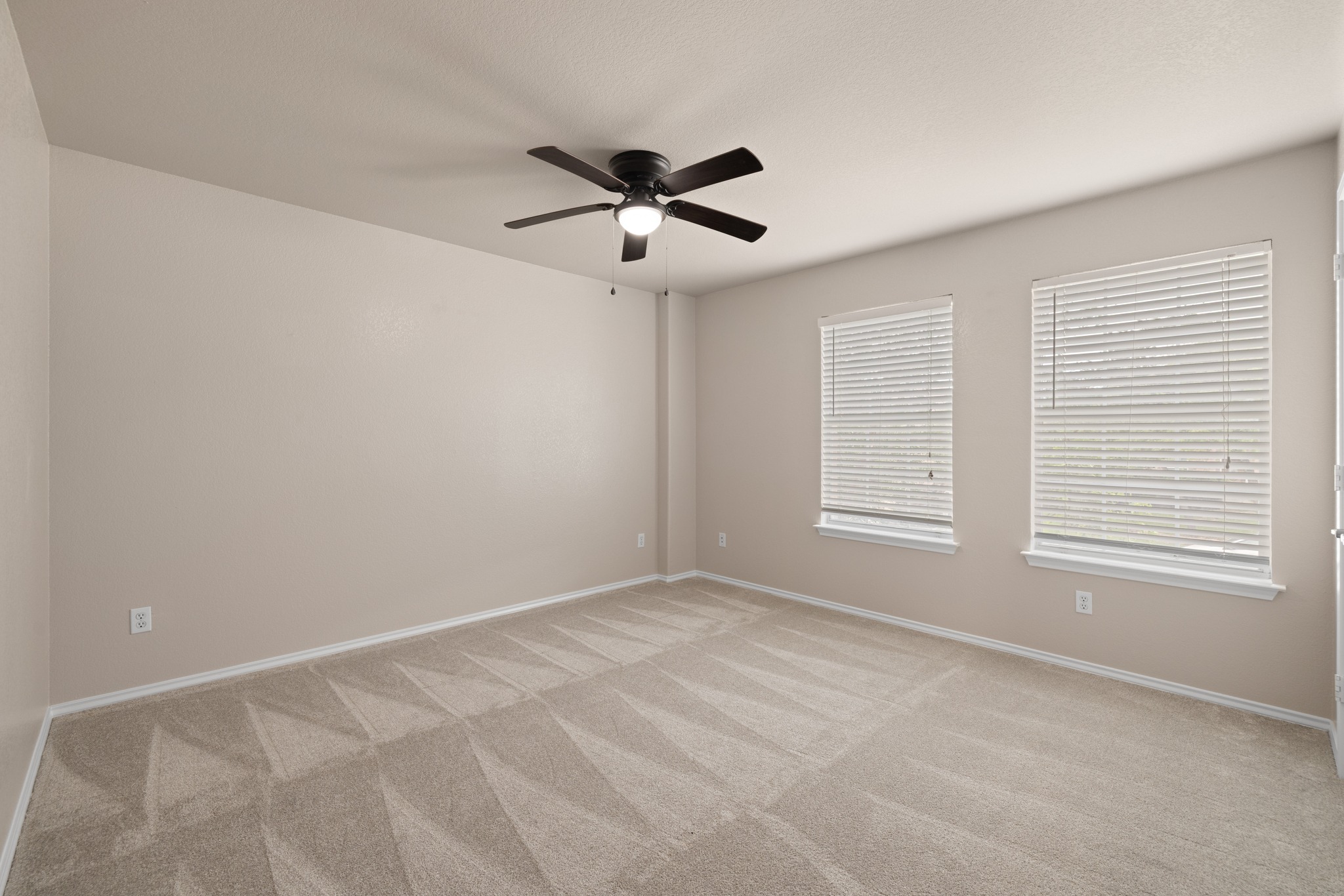 403 Red Hawk Drive Leander, TX 78641 - Photo 20 of 37 Spacious room featuring neutral-toned walls, patterned carpet, and a ceiling fan with integrated lighting