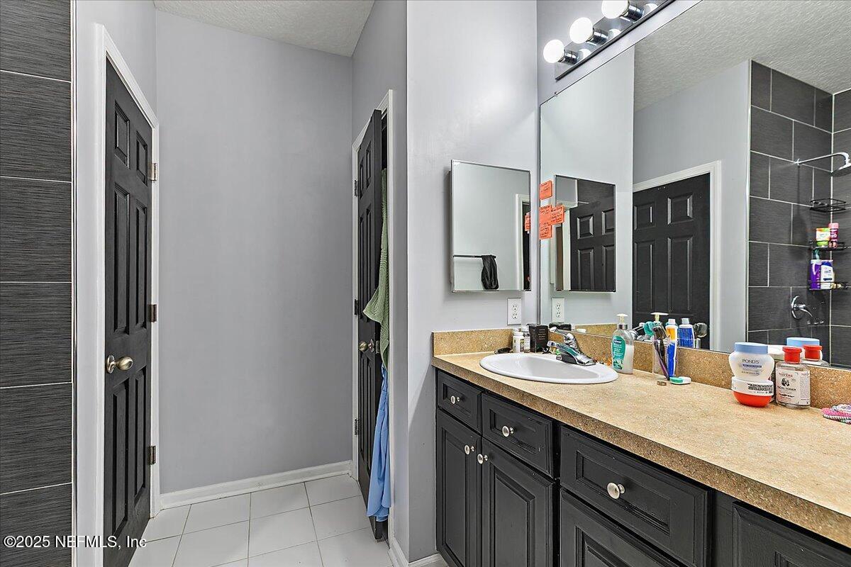 5663 Greenland Road, Unit 1201 Jacksonville, FL 32258 - Photo 12 of 18 a bathroom with a double vanity sink and a mirror