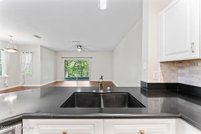 a view of a kitchen with a sink and wooden floor