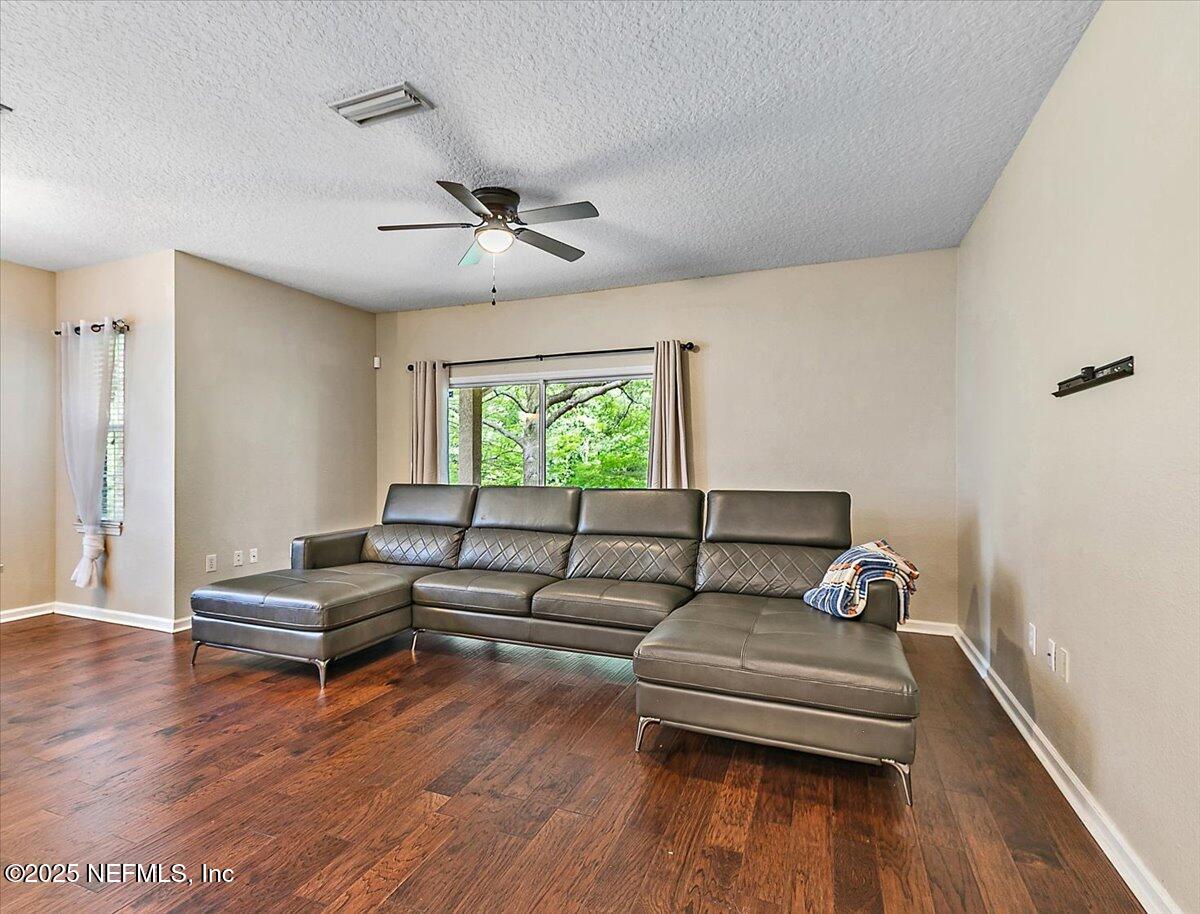5663 Greenland Road, Unit 1201 Jacksonville, FL 32258 - Photo 5 of 18 a living room with furniture and a wooden floor