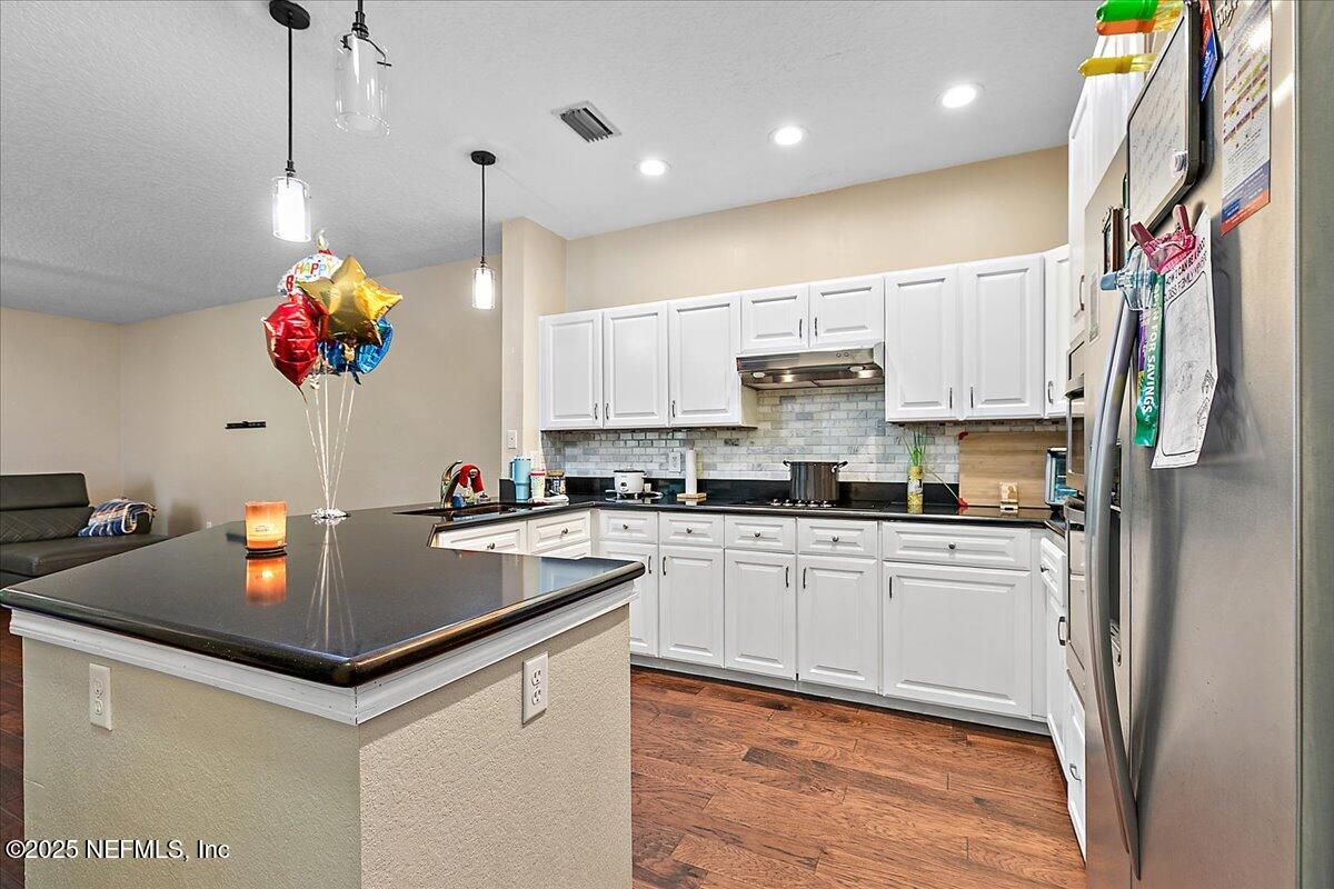 5663 Greenland Road, Unit 1201 Jacksonville, FL 32258 - Photo 8 of 18 a kitchen with kitchen island granite countertop a table and a chandelier