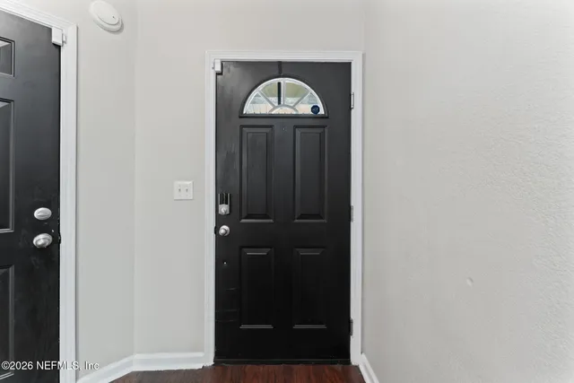 a kitchen with a stove a sink a kitchen island with wooden floor and windows