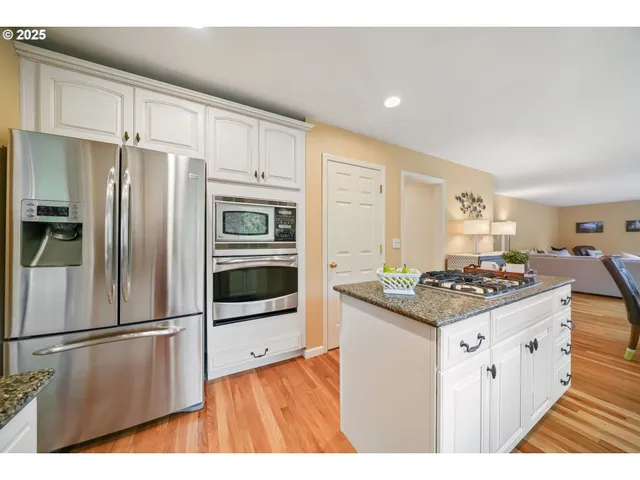 a kitchen with granite countertop white cabinets and window