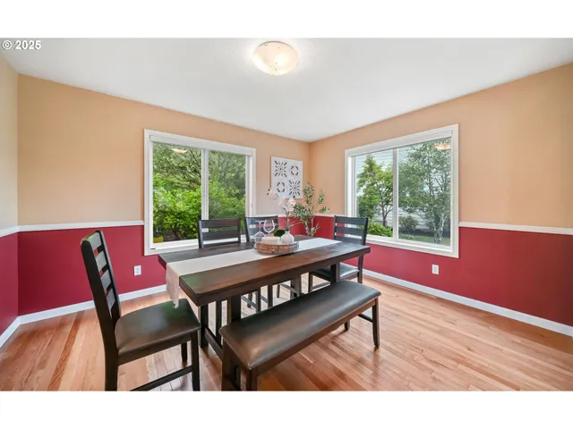 a living room with furniture a large window and wooden floor