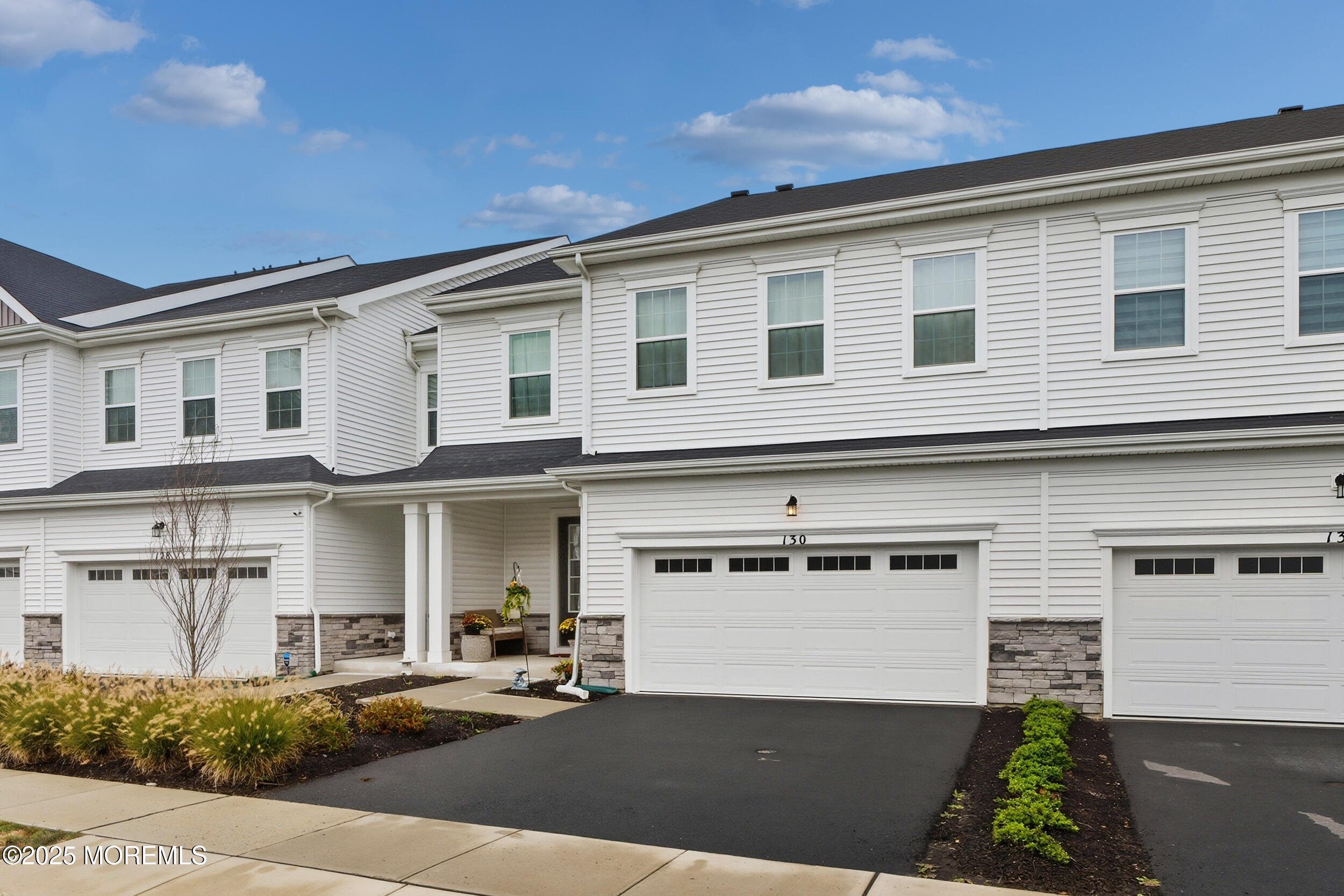 130 Woolley Court Oakhurst, NJ 07712 - Photo 1 of 34 a front view of a house with a garden and plants