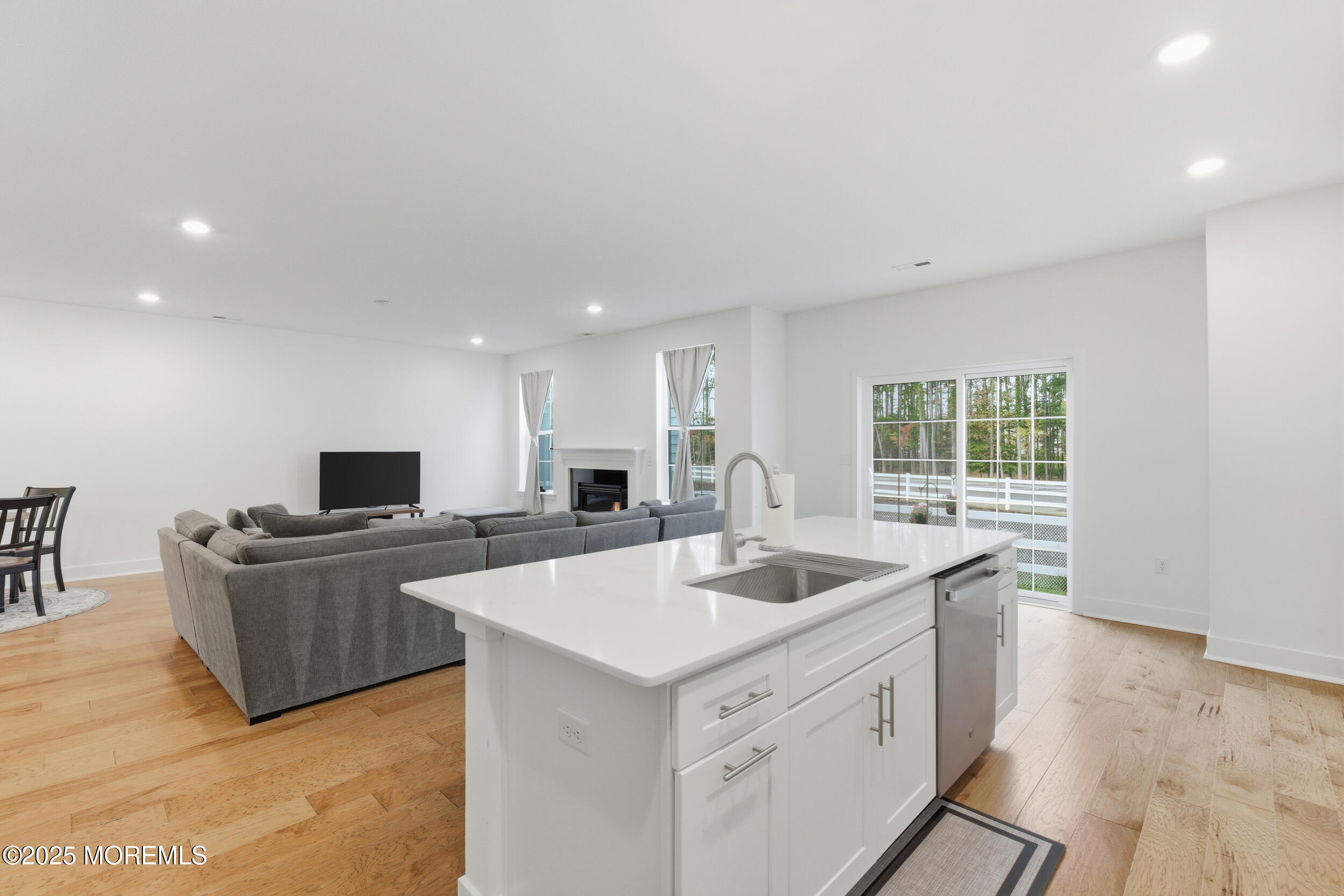 130 Woolley Court Oakhurst, NJ 07712 - Photo 12 of 34 a kitchen that has a sink and a stove top oven with wooden floor