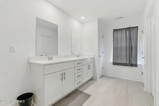 a spacious bathroom with 2 sink and a mirror