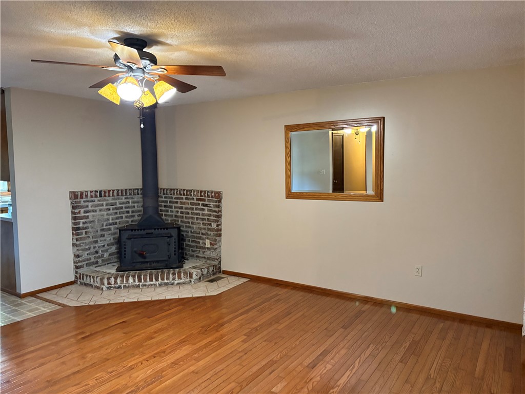 306 Hemlock Avenue Anderson, SC 29625 - Photo 4 of 25 Rich hardwood flooring complements a corner wood stove with a brick surround.