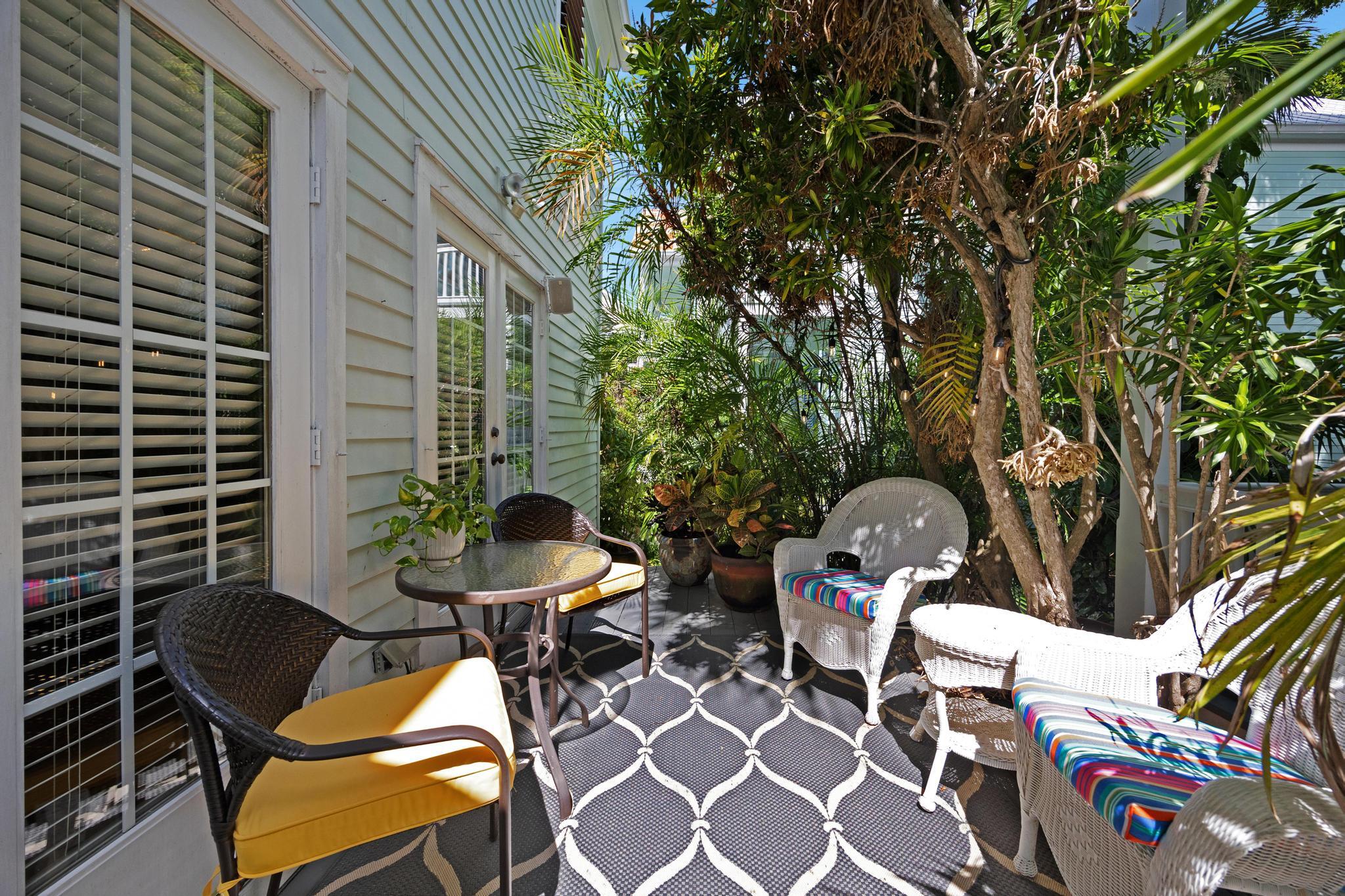 606 Truman Avenue, Unit 10 Key West, FL 33040 - Photo 17 of 20 a backyard of a house with table and chairs